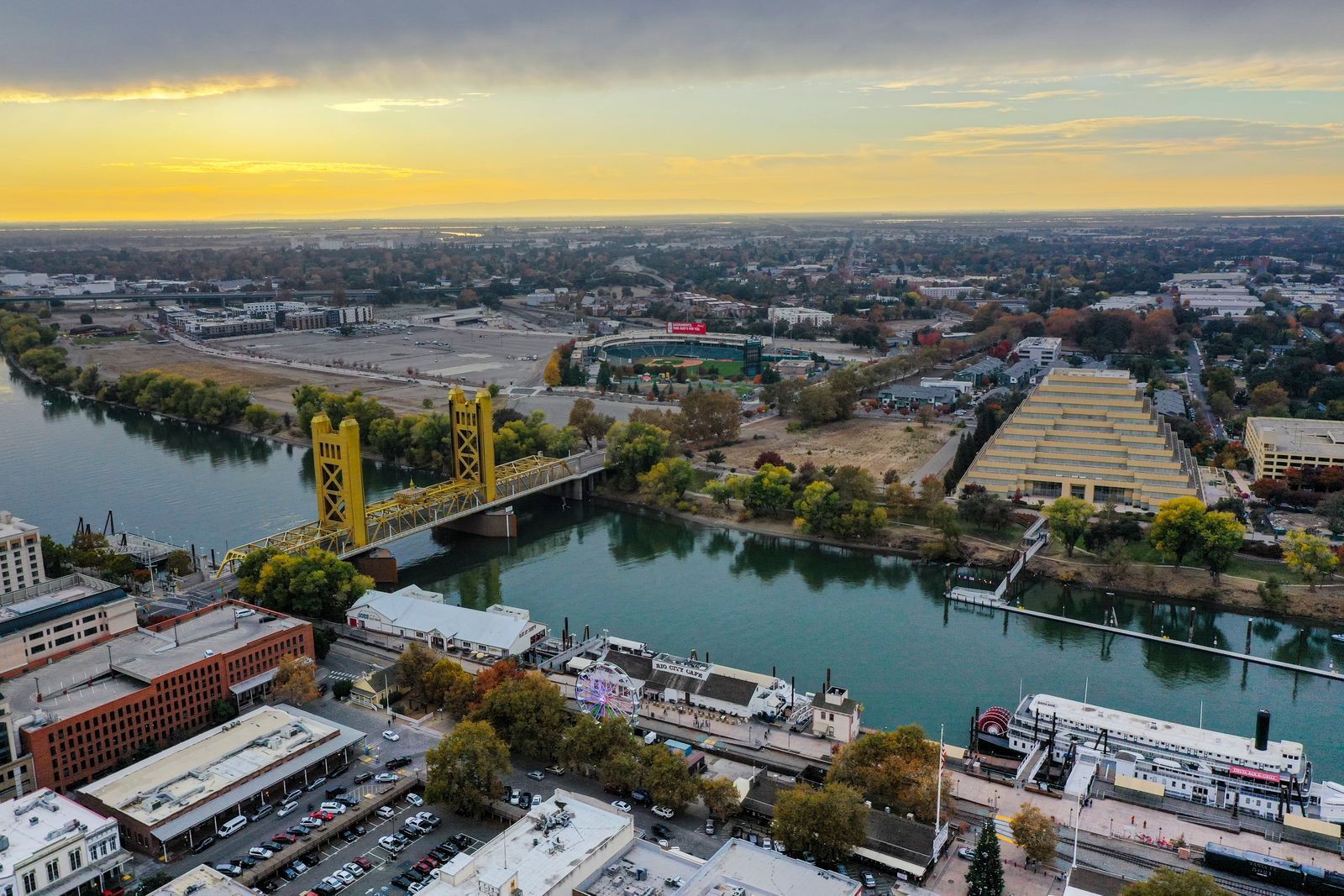 The gold Tower Bridge over the Sacramento River and the city at sunset, a port of call on California wine country river cruises